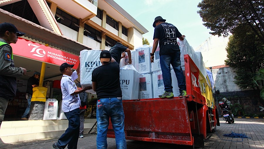 Petugas menaikkan logistik pilkada kedalam truk di kantor Kecamatan Tanah Abang, Selasa (26/11/2024). (Bloomberg Technoz/Andrean Kristianto)