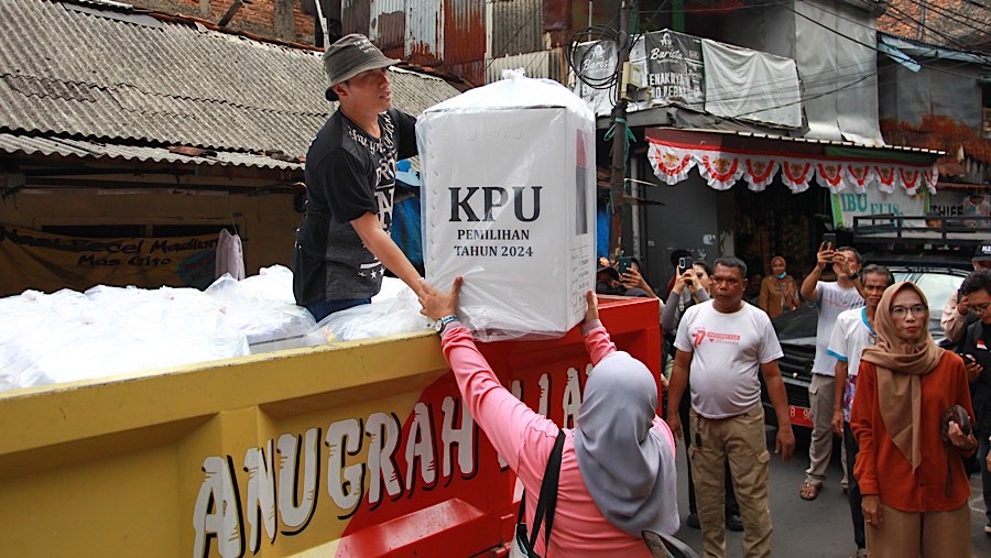 Petugas menurunkan logistik pilkada untuk dibawa ke kantor RW di kawasan Petamburan, Selasa (26/11/2024). (Bloomberg Technoz/Andrean Kristianto)
