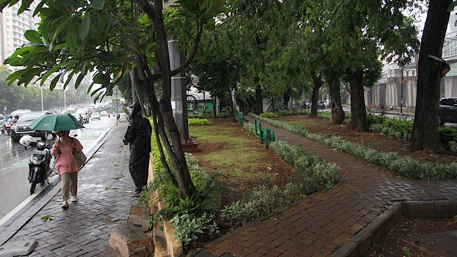 Warga berjalan saat hujan dan angin kencang di kawasan Casablanca, Jakarta, Selasa (3/12/2024). (Bloomberg Technoz/Andrean Kristianto)