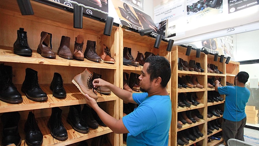 Rully Fauzul merapihkan sepatu di industri rumahan produk sepatu kulit, Cakung, Selasa (3/12/2024). (Bloomberg Technoz/Andrean Kristianto)