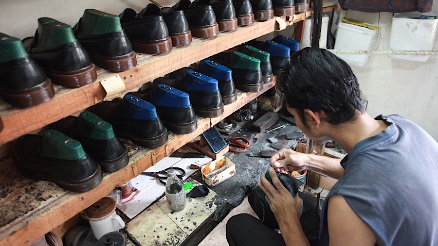 Pekerja menyelesaikan pembuatan sepatu di industri rumahan di Cakung, Jakarta Timur, Selasa (3/12/2024). (Bloomberg Technoz/Andrean Kristianto)

