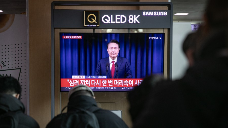 Layar TV tayangkan siaran langsung Presiden Korea Selatan Yoon Suk Yeol yang membungkuk minta maaf, Sabtu (7/12/2024). (Woohae Cho/Bloomberg)