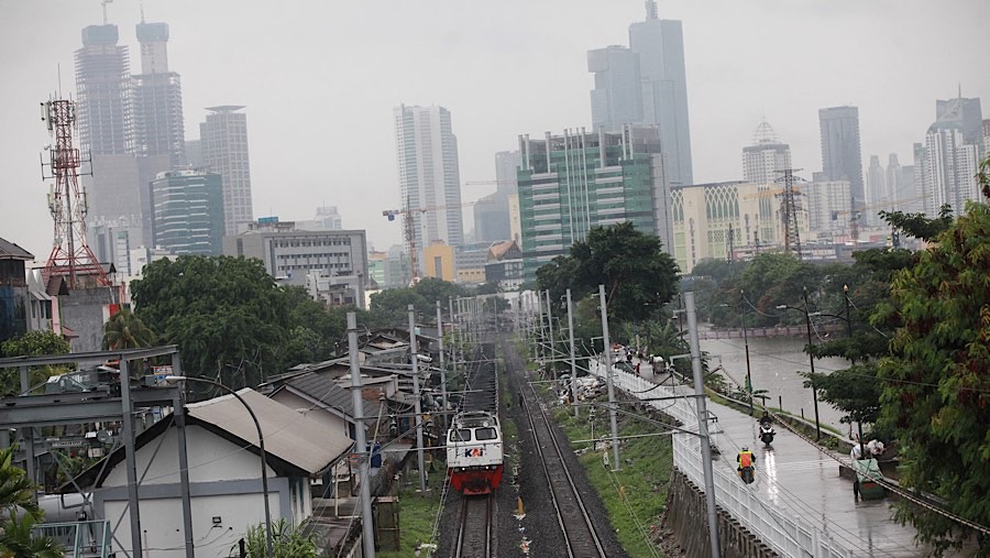 Kereta melintas dengan latar gedung di kawasan Tomang, Jakarta, Senin (9/12/2024). (Bloomberg Technoz/Andrean Kristianto)