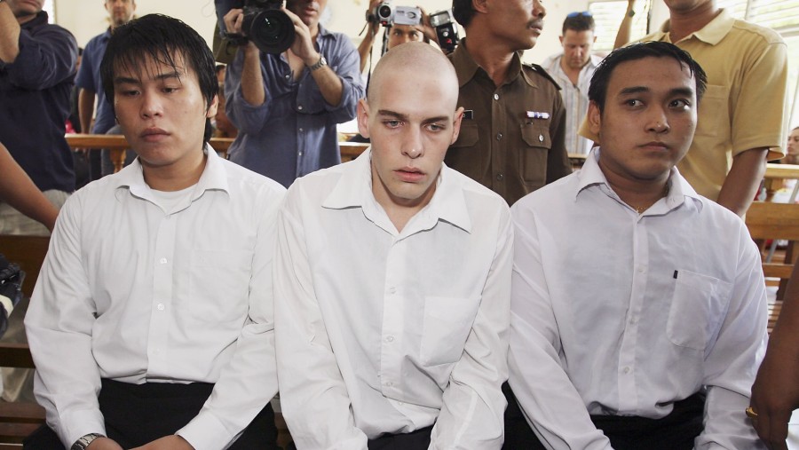 Matthew Norman duduk di antara Tan Duc Thanh Nguyen dan Si Yi Chen di ruang sidang PN Denpasar pada 2006. (Dimas Ardian/Getty Images via Bloomberg)