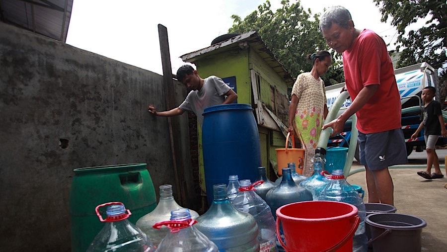 Warga mengantre bantuan air bersih di kawasan Lodan, Jakarta, Rabu (18/12/2024). (Bloomberg Technoz/Andrean Kristianto)