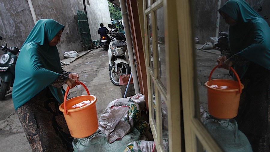 Untuk mendapatkan air bersih warga membawa ember yang diisi dari truk bantuan air bersih. (Bloomberg Technoz/Andrean Kristianto)