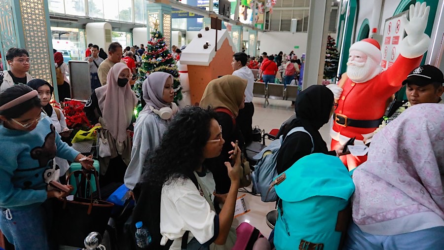 Penumpang kereta api jarak jauh antre menuju peron di Stasiun Senen, Jakarta, Senin (23/12/2024). (Bloomberg Technoz/Andrean Kristianto)