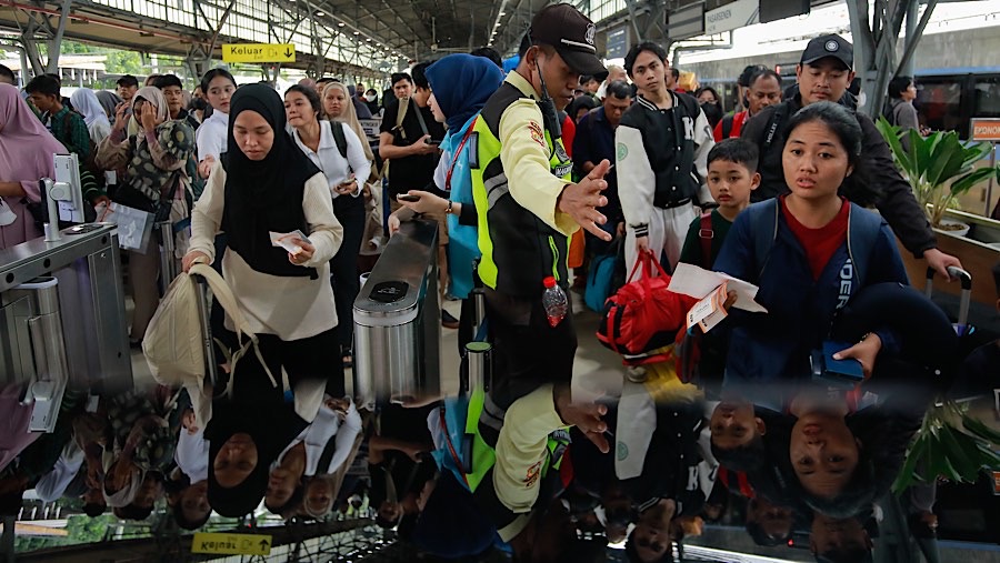Penumpang kereta api jarak jauh antre menuju peron di Stasiun Senen, Jakarta, Senin (23/12/2024). (Bloomberg Technoz/Andrean Kristianto)