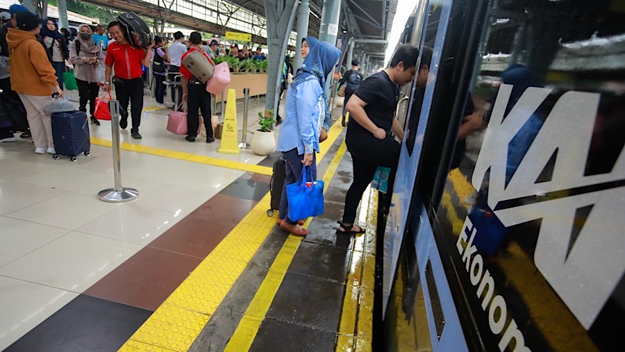 Penumpang menaiki gerbong kereta api jarak jauh di Stasiun Senen, Jakarta, Senin (23/12/2024). (Bloomberg Technoz/Andrean Kristianto)