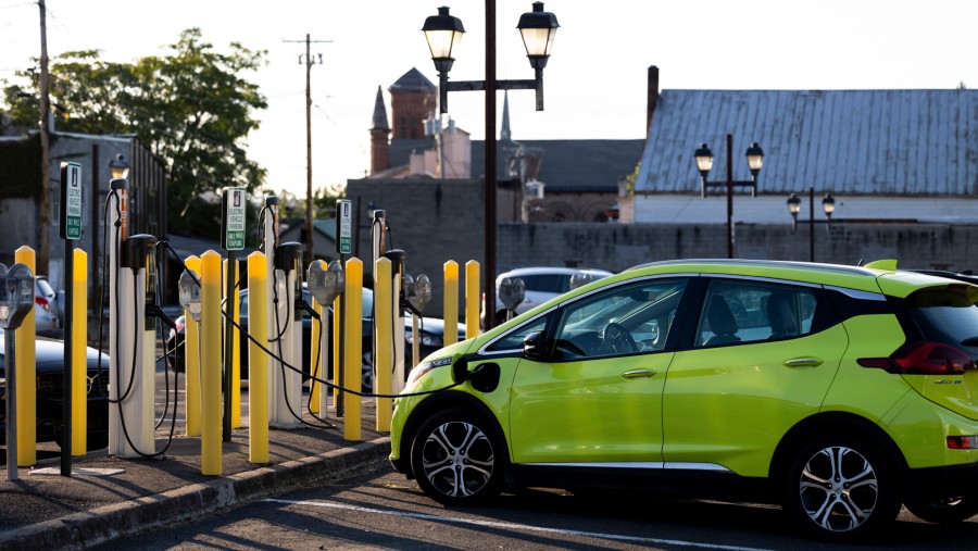 Sebuah mobil listrik mengisi daya baterai di charging station./Bloomberg-Angus Mordant