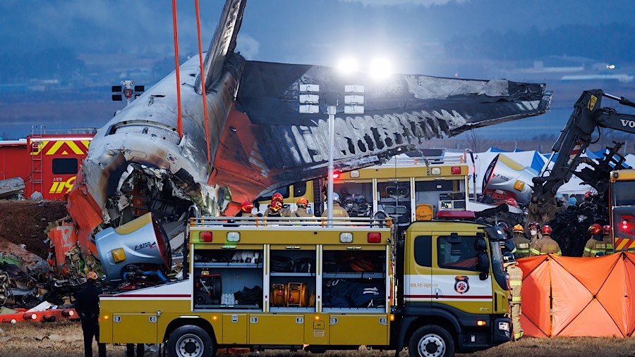 Puing-puing pesawat Jeju Air yang terbakar di Bandara Internasional Muan, Korea Selatan, Minggu (29/12/2024). (SeongJoon Cho/Bloomberg)