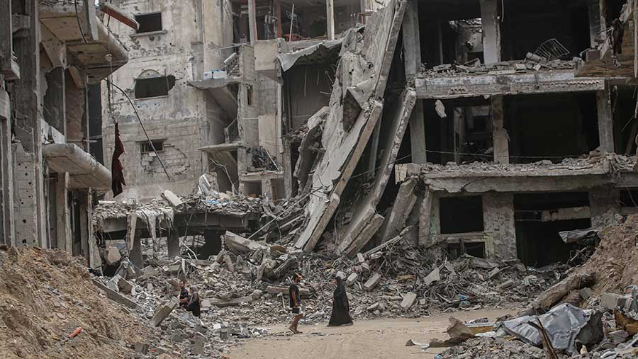 Pengungsi Palestina berjalan di antara reruntuhan Khan Younis, Gaza selatan, Selasa (28/5/2024). (Ahmad Salem/Bloomberg)