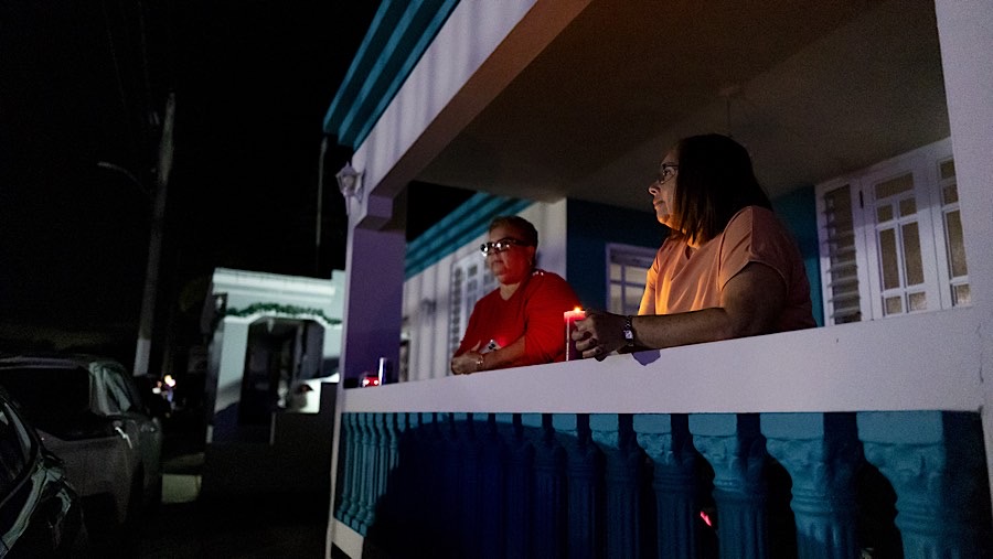 Warga memegang lilin pada Malam Tahun Baru saat listrik padam di Patillas, Puerto Riko, Selasa (31/12/2024). (Xavier Garcia/Bloomberg)