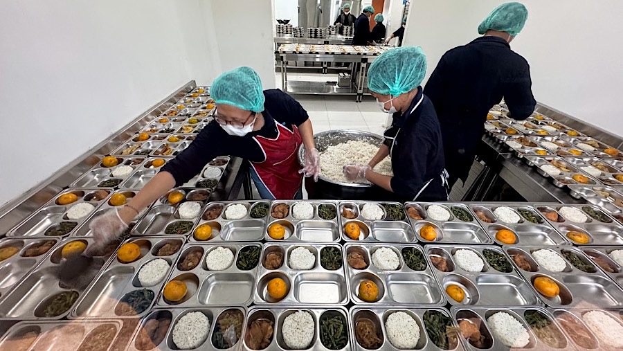 Petugas menyiapkan paket makanan bergizi gratis (MBG) di SPPG Pamerah, Jakarta, Senin (6/1/2025). (Bloomberg Technoz/Andrean Kristianto)