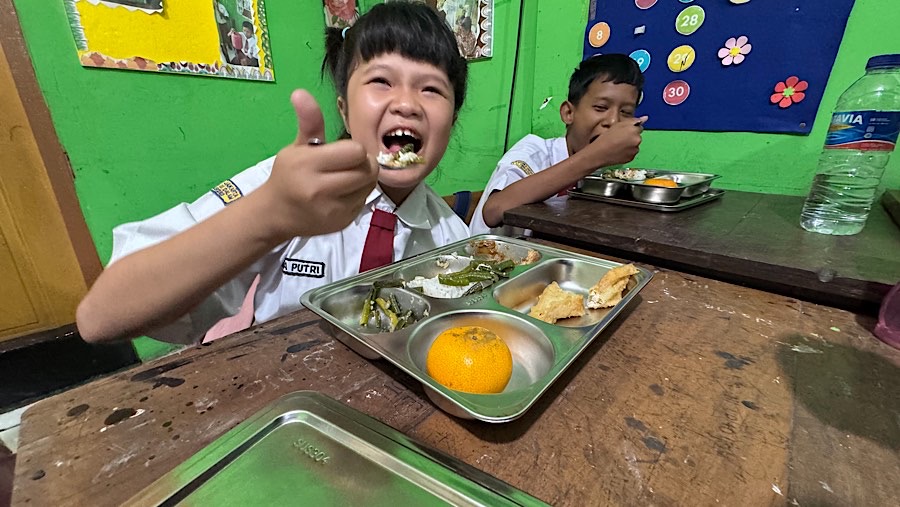 Murid menyantap makanan bergizi gratis (MBG) di SLBN 5 Slipi, Jakarta, Senin (6/1/2025). (Bloomberg Technoz/Andrean Kristianto)