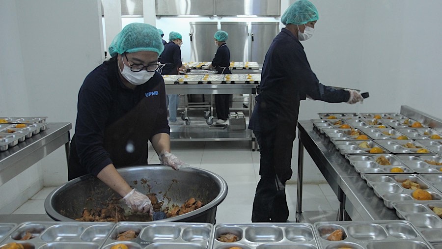 Petugas menyiapkan paket makanan bergizi gratis (MBG) di SPPG Pamerah, Jakarta, Senin (6/1/2025). (Bloomberg Technoz/Andrean Kristianto)