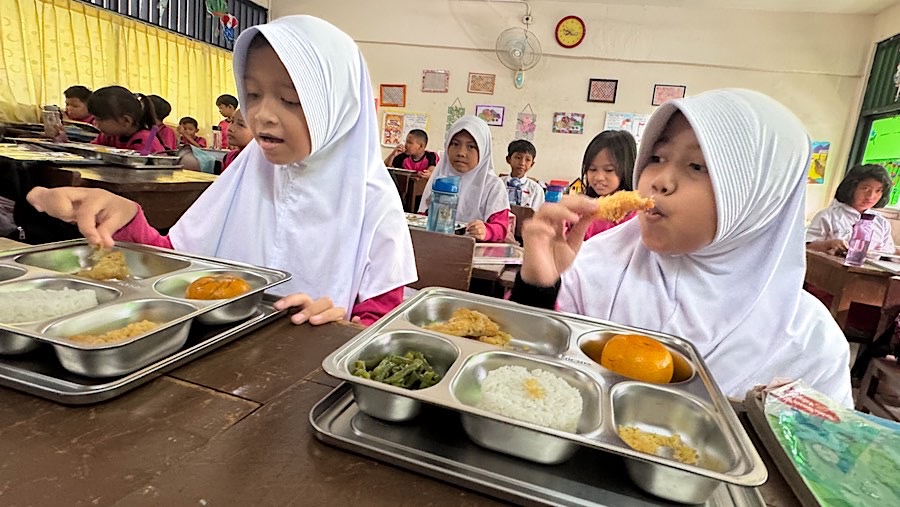 Sejumlah murid menyantap makanan bergizi gratis (MBG) di SDN 15 Slipi, Jakarta, Senin (6/1/2025). (Bloomberg Technoz/Andrean Kristianto)