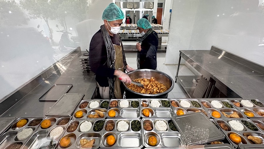 Petugas menyiapkan paket makanan bergizi gratis (MBG) di SPPG Pamerah, Jakarta, Senin (6/1/2025). (Bloomberg Technoz/Andrean Kristianto)