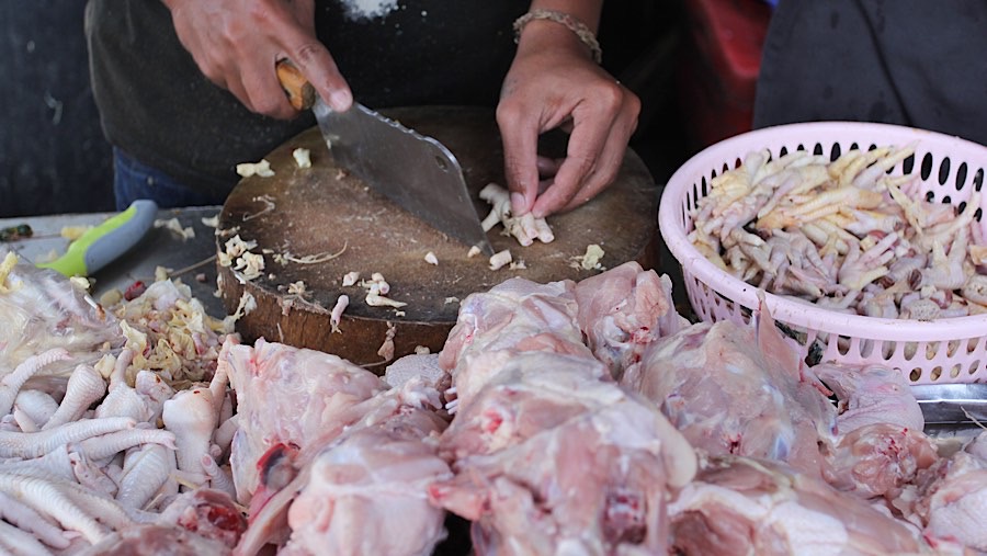 Pedagang memotong daging ayam di Pasar Kebayoran Lama, Jakarta, Selasa (7/12/2025). (Bloomberg Technoz/Andrean Kristianto)
