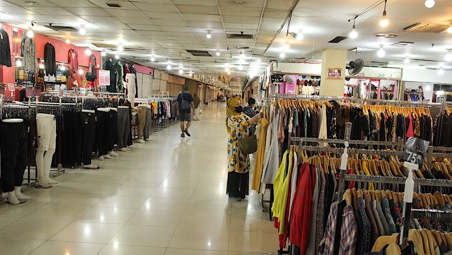 Warga melinat baju yang dijual di Mal Blok M, Jakarta, Rabu (8/1/2025). (Bloomberg Technoz/Andrean Kristianto)
