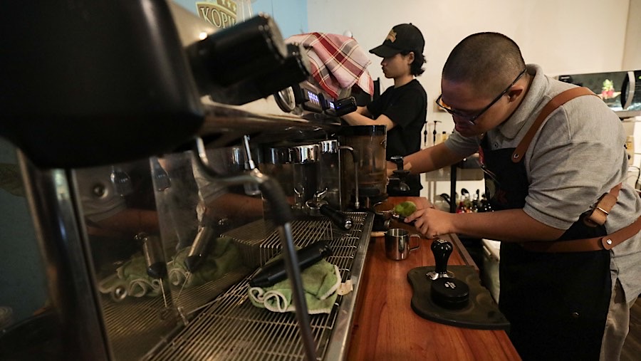 Seorang barista penyandang disabilitas down syndrom membuat kopi di Kopi Kamu, Jakarta, Kamis (9/1/2025). (Bloomberg Technoz/Andrean Kristianto)
