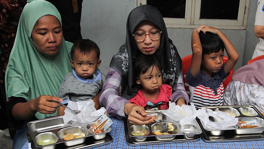 Ibu hamil menerima porsi Makan Bergizi Gratis (MBG) dengan nasi dan sayur yang lebih banyak. (Bloomberg Technoz/Andrean Kristianto)