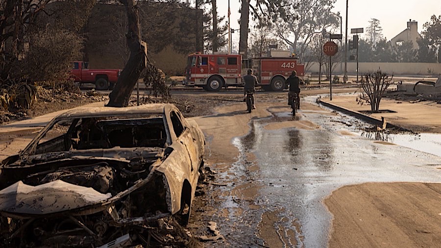 Warga bersepeda melewati sisa-sisa kebakaran Palisades di Palisades, California, AS, Kamis (9/1/2025). (Michael Nigro/Bloomberg)