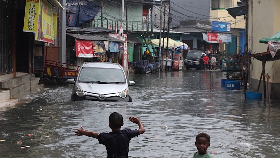 Beberapa kendaraan terlihat mencoba menerobos banjir. (Bloomberg Technoz/Andrean Kristianto)