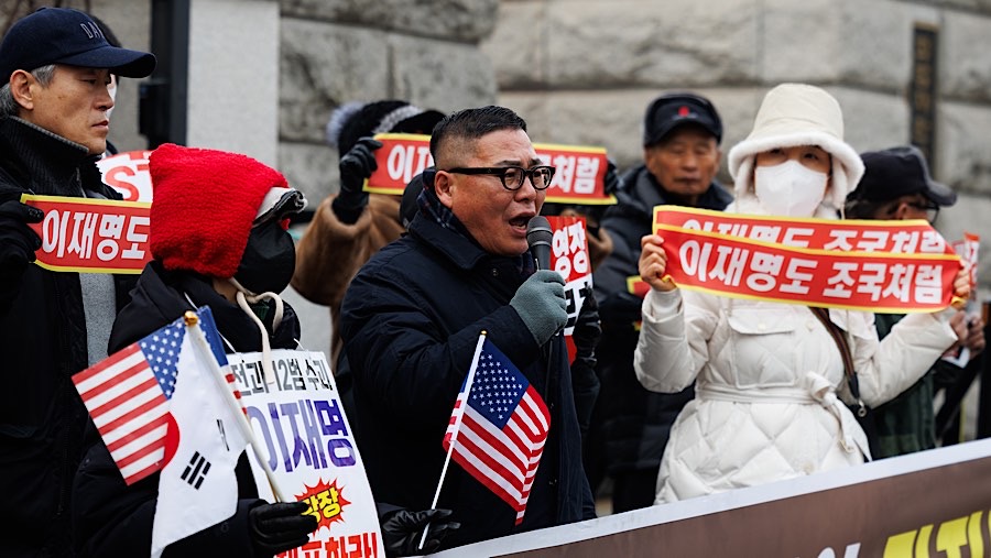 Mereka memprotes pemakzulan dan membawa spanduk bertuliskan upaya penangkapan oleh penyelidik tersebut ilegal. (SeongJoon Cho/Bloomberg)