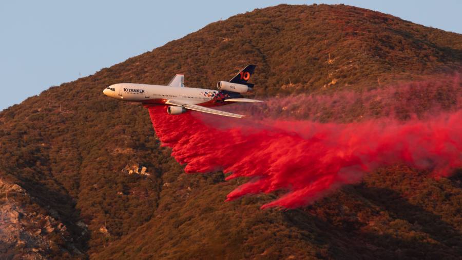 Pesawat menjatuhkan bahan pemadam api selama kebakaran di Los Angeles, California. (Benjamin Fanjoy/Bloomberg)