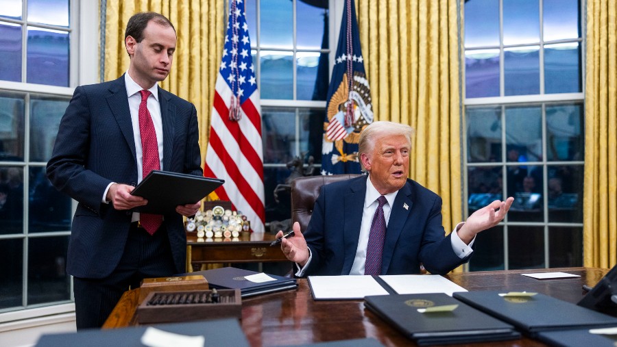 Presiden AS Donald Trump di meja kerja, Oval Office, setelah pengambilan sumpah jabatan (Bloomberg)