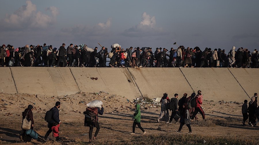 Warga Palestina berjalan menuju rumah mereka di Gaza utara, melalui Koridor Netzarim di Gaza tengah, Senin (27/1/2025). (Ahmad Salem/Bloomberg)
