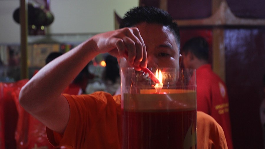 Umat meenyalakan lilin untuk sembahyang Imlek di Vihara Punna Karya, Banten, Selasa (28/1/2025). (Bloomberg Technoz/Andrean Kristianto)