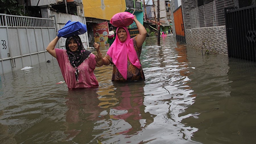 Warga melintasi banjir di kawasan pemukiman Rawa Buaya, Jakarta Barat, Rabu (29/1/2025). (Bloomberg Technoz/Andrean Kristianto)