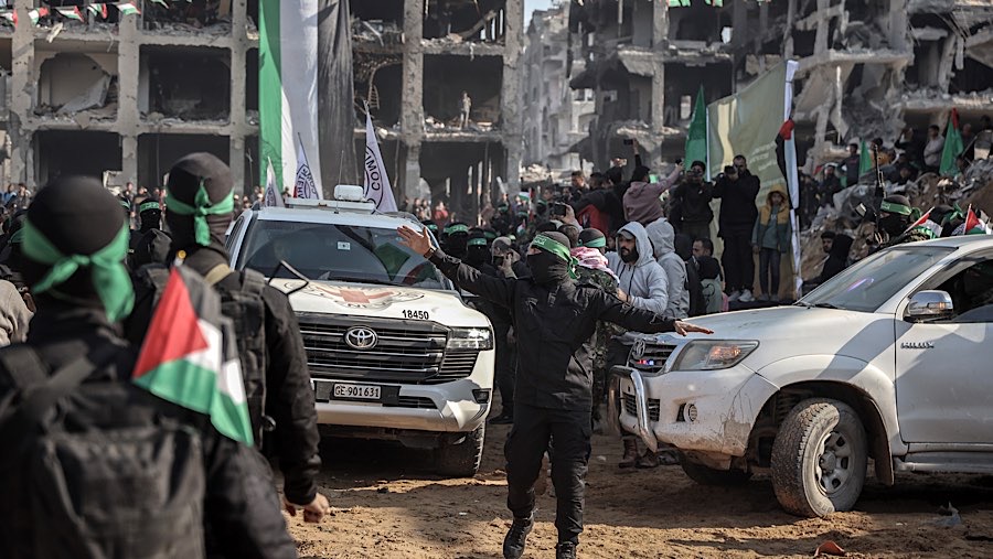 Militan Hamas memandu kendaraan Palang Merah sebelum pembebasan sandera Israel di kamp Jabalia, Gaza utara, Kamis (30/1/2025). (Ahmad Salem/Bloomberg)