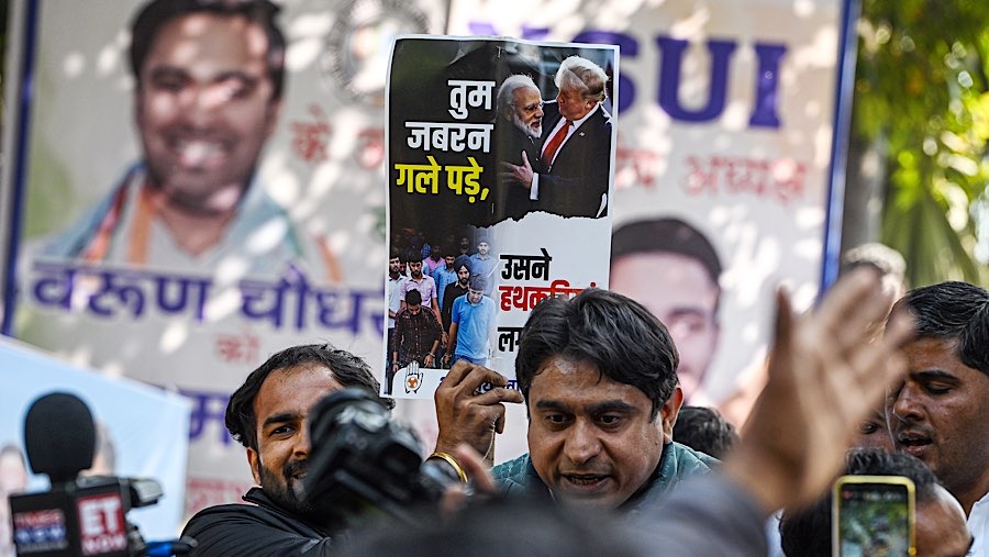 Pedemo memegang poster Narendra Modi, dan Donald Trump selama protes di New Delhi, India, Kamis (6/2/2025). (Prakash Singh/Bloomberg)