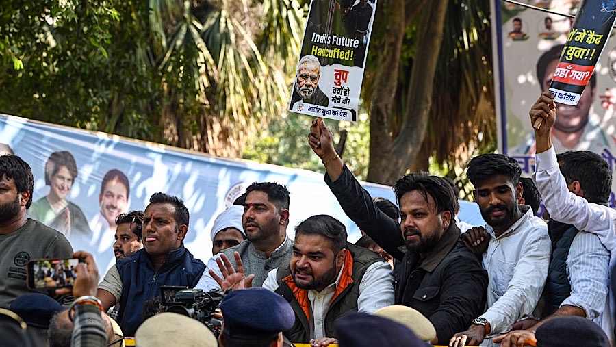Anggota parlemen oposisi di India menggelar unjuk rasa di luar gedung parlemen dengan membawa poster. (Prakash Singh/Bloomberg)