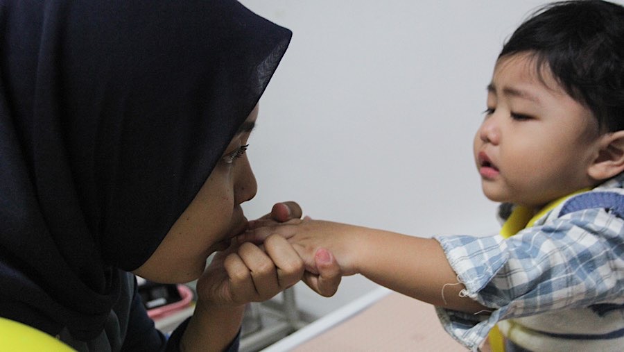 Seorang ibu menemani anaknya saat cek kesehatan gratis di Puskesmas Kebayoran Baru, Senin (10/2/2025). (Bloomberg Technoz/Andrean Kristianto)