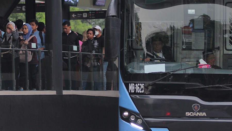 Penumpang mengantre untuk menaiki Transjakarta di Jakarta, Selasa (11/2/2025). (Bloomberg Technoz/Andrean Kristianto)