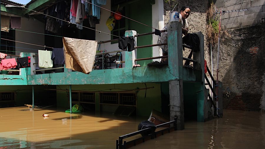 Warga yang tak mengungsi memanfaatkan lantai atas rumah mereka untuk bertahan. (Bloomberg Technoz/Andrean Kristianto)