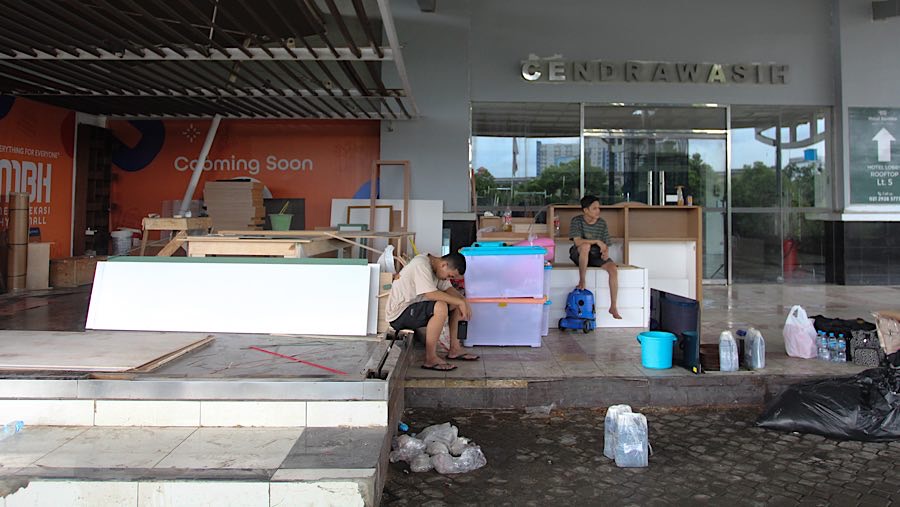 Beberapa pedagang berusaha menyelamatkan barang dagangannya. (Bloomberg Technoz/Andrean Kristianto)