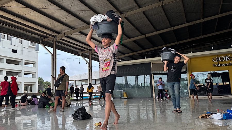 Pedagang menyelematkan dagangan saat banjir melanda Mega Bekasi Hypermall di Bekasi, Jabar, Selasa (4/3/2025). (Bloomberg Technoz/Andrean Kristianto)