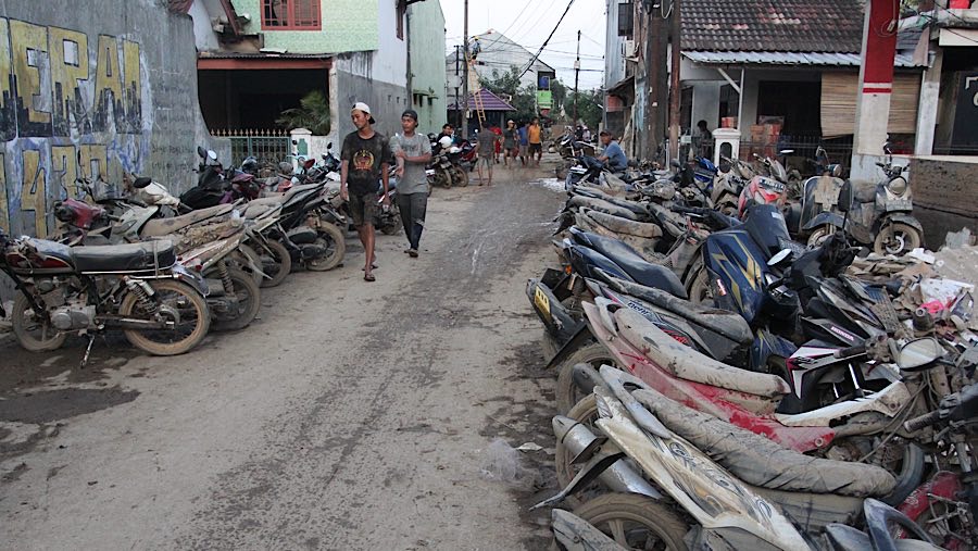 Sejumlah kendaraan yang terdampak banjir masih dipenuhi lumpur. (Bloomberg Technoz/Andrean Kristianto)