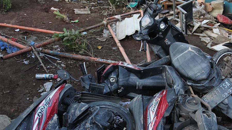 Beberapa kendaraan roda dua tergeletak usai terjangan banjir yang melanda perumahan tersebut. (Bloomberg Technoz/Andrean Kristianto)