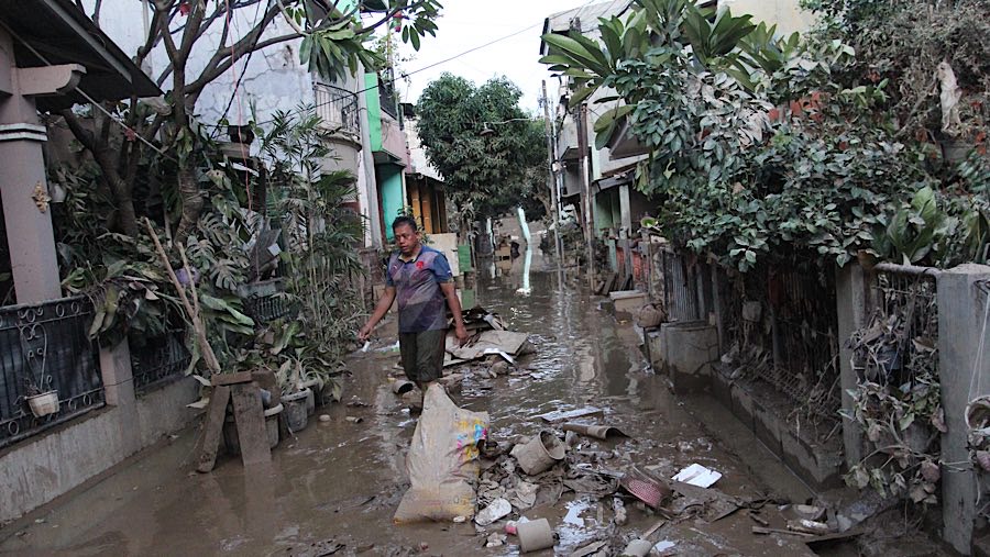 Meskipun banjir telah surut, namun warga masih harus berjibaku membersihkan lumpur. (Bloomberg Technoz/Andrean Kristianto)