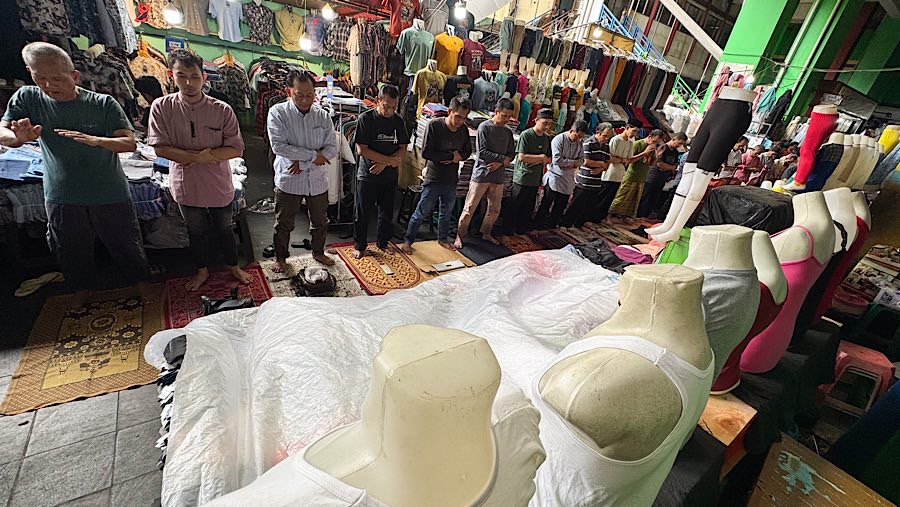 Mereka terpaksan melaksanakan salat di lorong-lorong pasar karena keterbatasan ruang di Masjid Nurul Muhajirin. (Bloomberg Technoz/Andrean Kristianto)