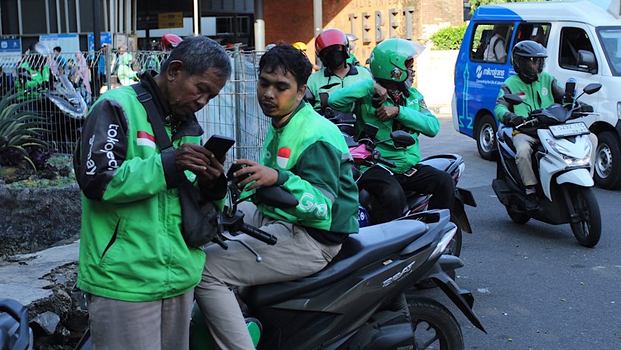 Driver ojek daring (ojol) berbincang dengan temannya di kawasan Tebet, Jakarta, Rabu (12/3/2025). (Bloomberg Technoz/Andrean Kristianto)