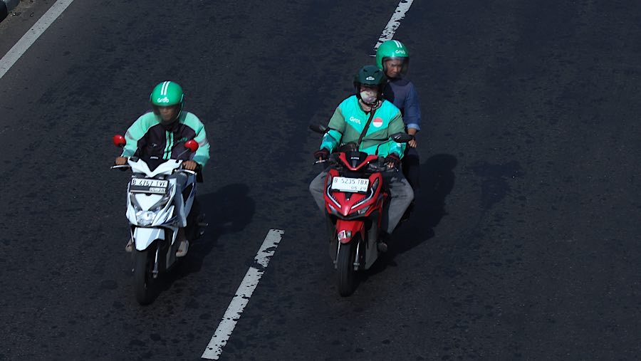 Driver ojek daring (ojol) melintas di kawasan Bukit Duri, Jakarta, Rabu (12/3/2025). (Bloomberg Technoz/Andrean Kristianto)
