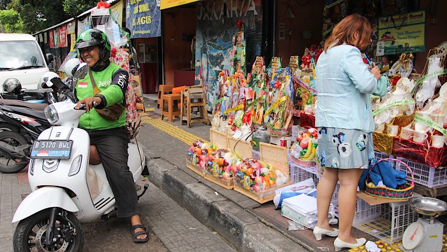 Driver ojek online membawa parsel yang akan dikirim di Jalan Barito, Jakarta, Rabu (19/3/2025). (Bloomberg Technoz/Andrean Kristianto)