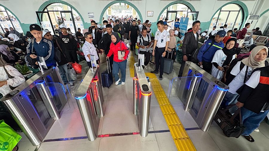 Pemudik menuju peron keberangkatan kereta api jarak jauh di Stasiun Pasar Senen, Rabu (26/3/2025). (Bloomberg Technoz/Andrean Kristianto)